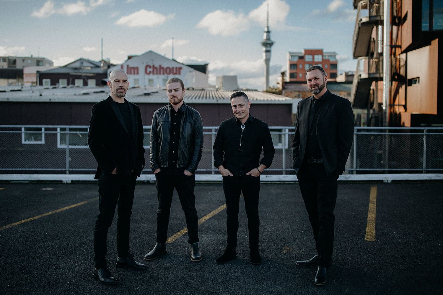 Hands Off band members in all-black on Auckland rooftop — corporate event entertainment